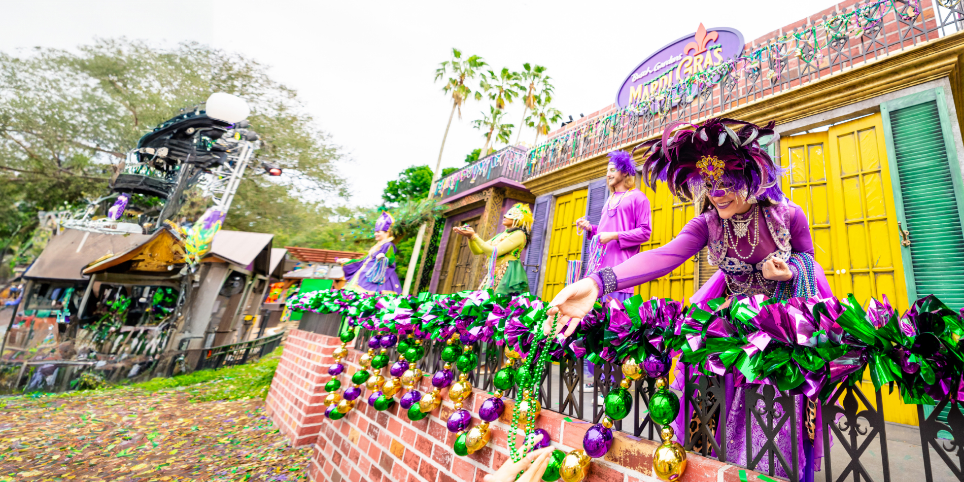 Friends visiting "Bead Balcony" for an opportunity to catch beads and celebrate at Busch Gardens Tampa Bay Mardi Gras.