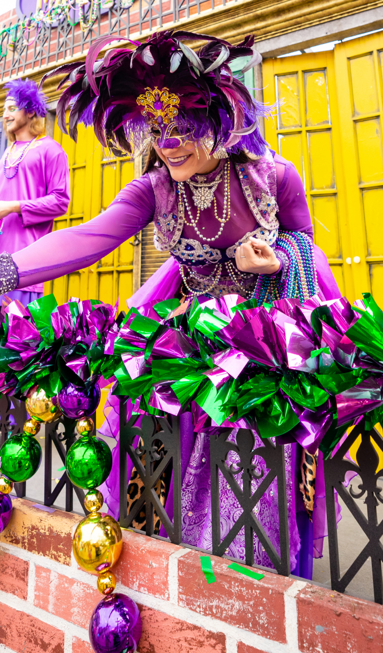 Friends visiting "Bead Balcony" for an opportunity to catch beads and celebrate at Busch Gardens Tampa Bay Mardi Gras.