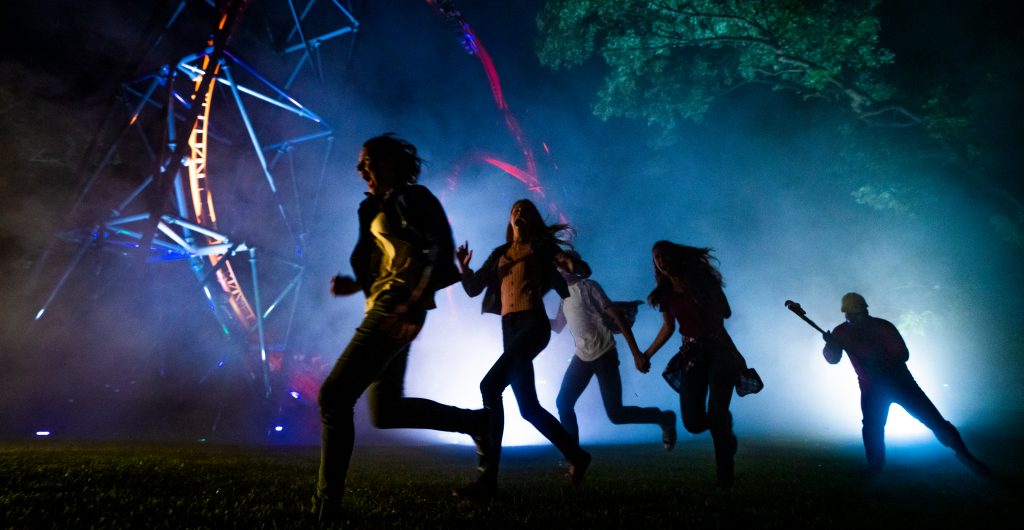 People running away from a scare-actor at Busch Gardens Howl-O-Scream